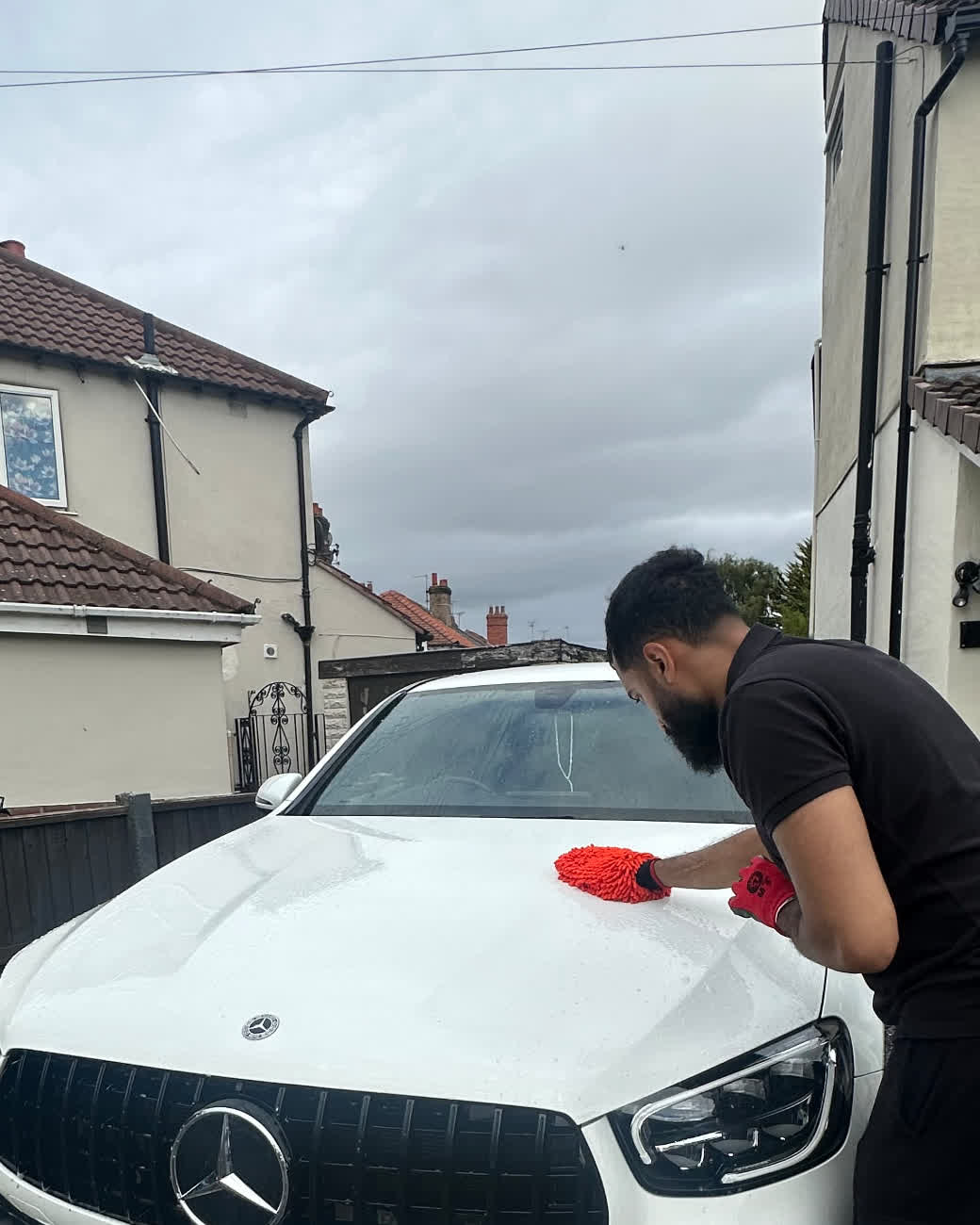 Niz hand-washing a white Mercedes with a microfibre mitt in Chester